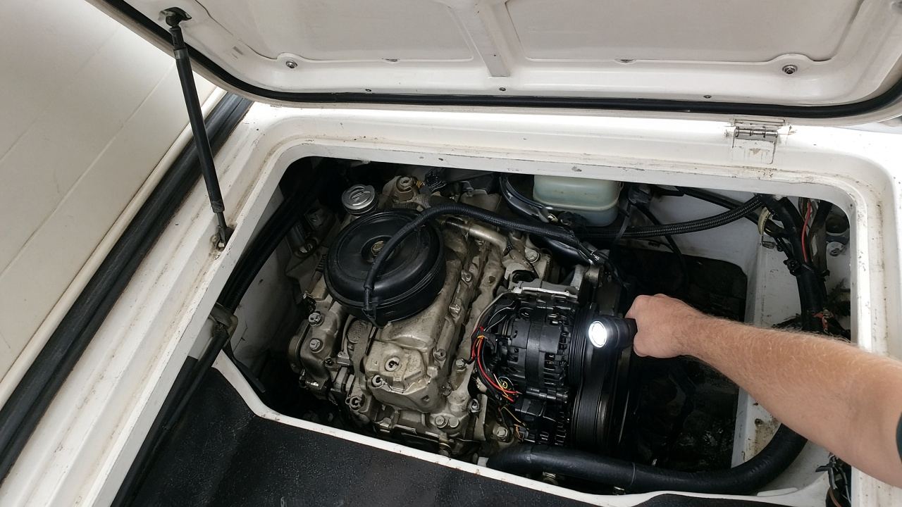 Moteur diesel in-bord dans la cale ouverte d'une vedette, lampe frontale allumée